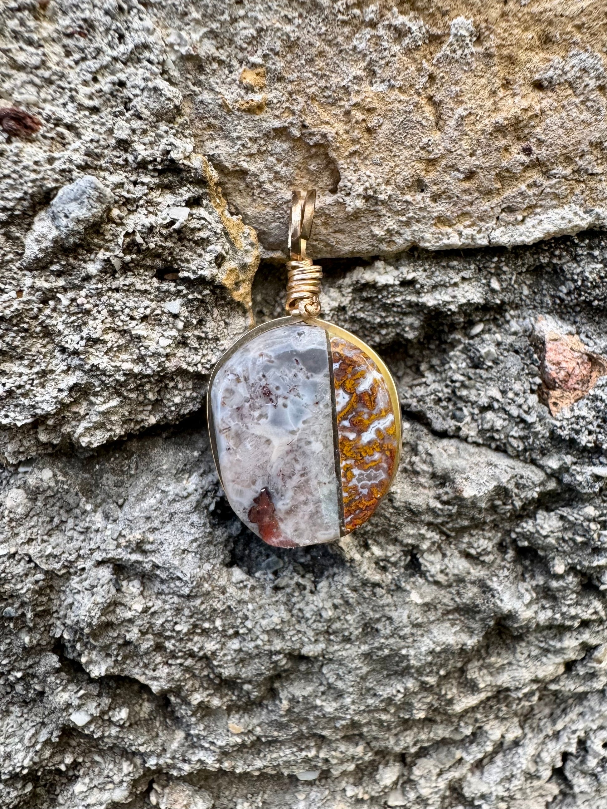 Pendant with a natural stone design hanging on a textured stone wall